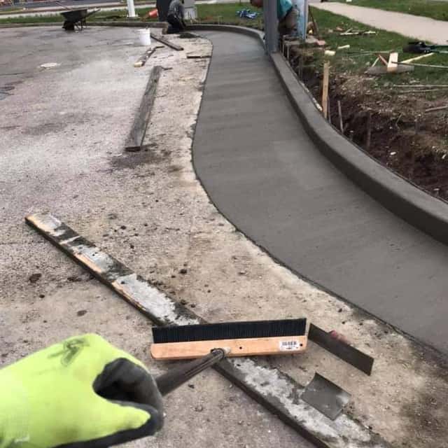 Crew screeding a long curved sidewalk pour along a commercial lot — JFC Concrete LLC, Indianapolis, IN