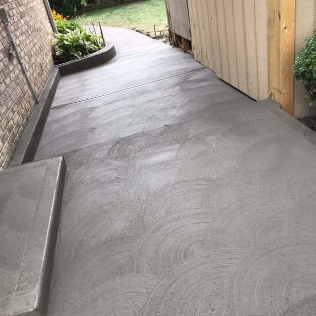 Swirl-finished side walkway and step running alongside a brick home — JFC Concrete LLC, Indianapolis, IN