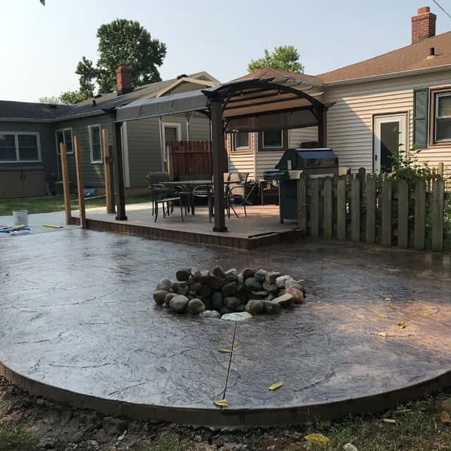 Stamped concrete patio with a built-in fire pit behind a home with a pergola — JFC Concrete LLC, Indianapolis, IN