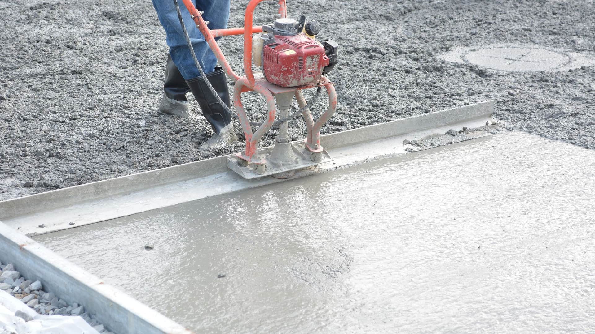 A power screed drawing off the edge of a freshly poured concrete slab